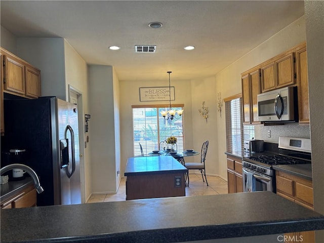 1800 Windermere Dr, Lancaster, CA 93534 - kitchen featuring appliances with stainless steel finishes, a center island, healthy amount of natural light, light tile patterned floors, and recessed lighting