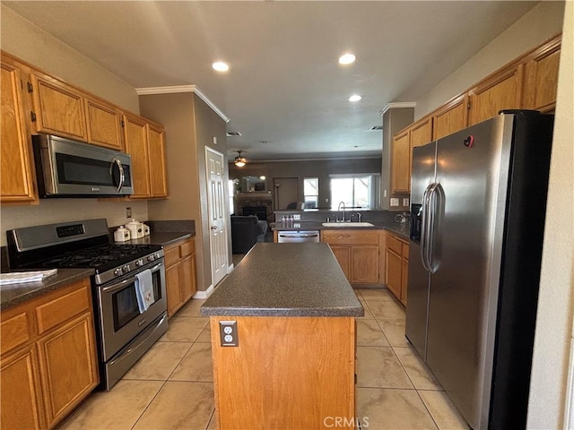 1800 Windermere Dr, Lancaster, CA 93534 - kitchen with appliances with stainless steel finishes, dark countertops, ornamental molding, a kitchen island, and light tile patterned floors