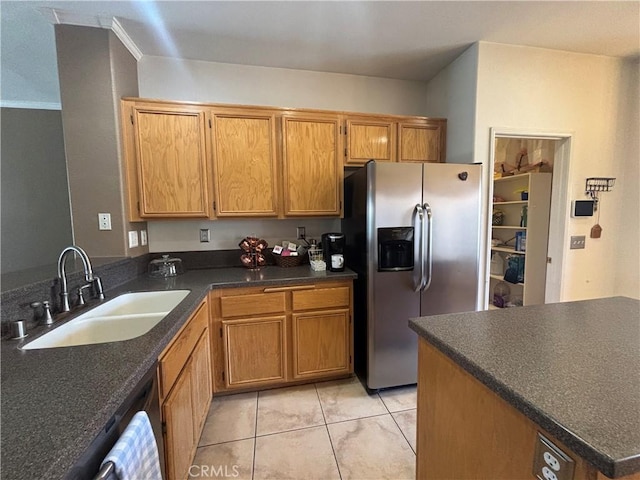 1800 Windermere Dr, Lancaster, CA 93534 - kitchen featuring stainless steel refrigerator with ice dispenser, a sink, dark countertops, light tile patterned flooring, and brown cabinets