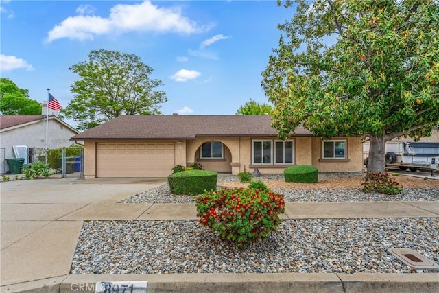 single story home featuring an attached garage, concrete driveway, stucco siding, and a gate