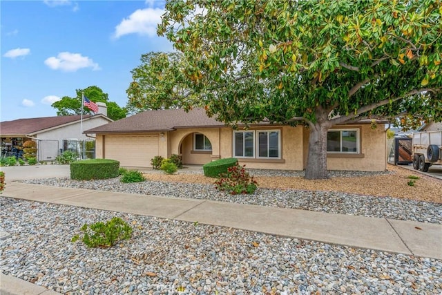 single story home with a garage, stucco siding, concrete driveway, and fence