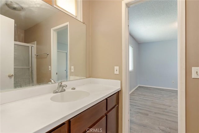 bathroom featuring wood finished floors, vanity, and baseboards