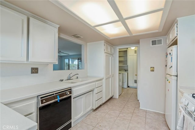 kitchen with white appliances, a sink, and white cabinetry
