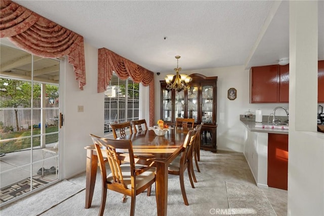 12018 Cherrywood Dr, Fontana, CA 92337 - dining room featuring a chandelier, a textured ceiling, and light carpet