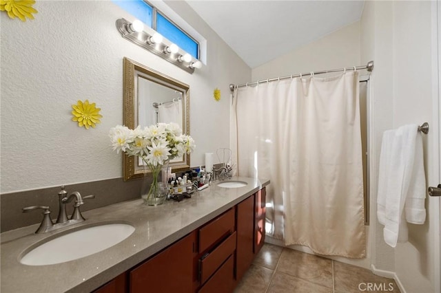 12018 Cherrywood Dr, Fontana, CA 92337 - bathroom with double vanity, lofted ceiling, tile patterned floors, and a textured wall