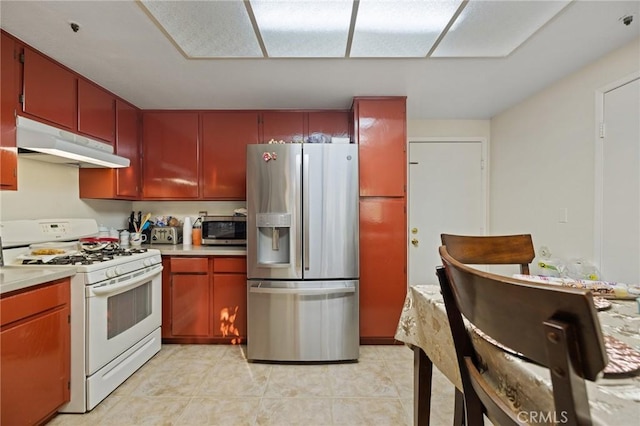 12018 Cherrywood Dr, Fontana, CA 92337 - kitchen with stainless steel appliances, under cabinet range hood, light countertops, and light tile patterned floors