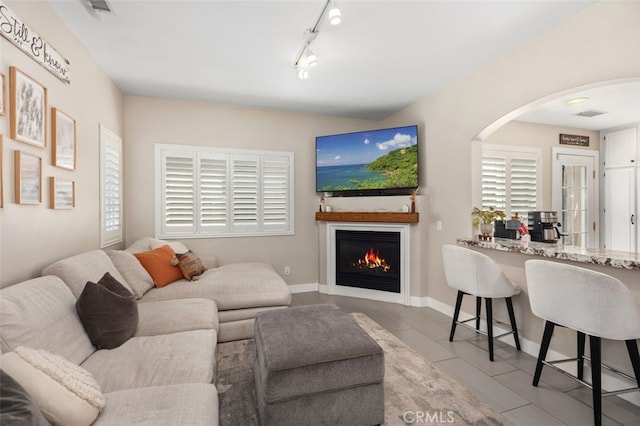 130 Bloomfield Ln, Rancho Santa Margarita, CA 92688 - tiled living room with arched walkways, rail lighting, and a warm lit fireplace