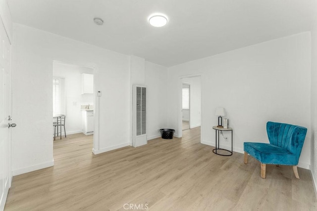 9309 S Broadway, Los Angeles, CA 90003 - living area featuring a heating unit, light wood-type flooring, and baseboards