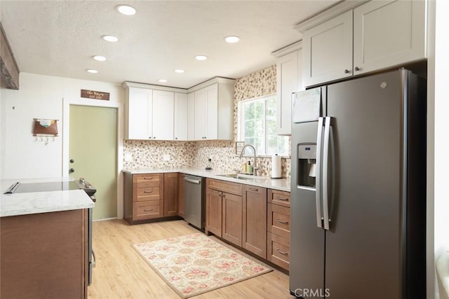 49 Bob Way, Oroville, CA 95965 - kitchen with appliances with stainless steel finishes, a sink, light wood finished floors, decorative backsplash, and recessed lighting