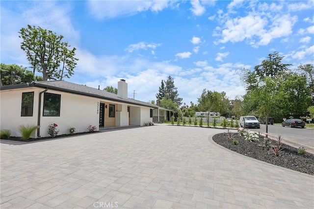 23240 Leonora Dr, Woodland Hills, CA 91367 - view of front facade featuring stucco siding, a chimney, and curved driveway
