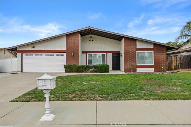 12705 Foreman Ave, Moreno Valley, CA 92553 - mid-century modern home with concrete driveway, stucco siding, an attached garage, and brick siding