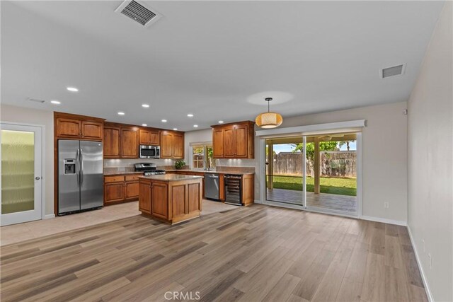 12705 Foreman Ave, Moreno Valley, CA 92553 - kitchen featuring stainless steel appliances, light wood-style floors, recessed lighting, baseboards, and brown cabinetry