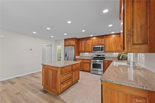 12705 Foreman Ave, Moreno Valley, CA 92553 - kitchen with appliances with stainless steel finishes, a sink, brown cabinets, light stone countertops, and recessed lighting