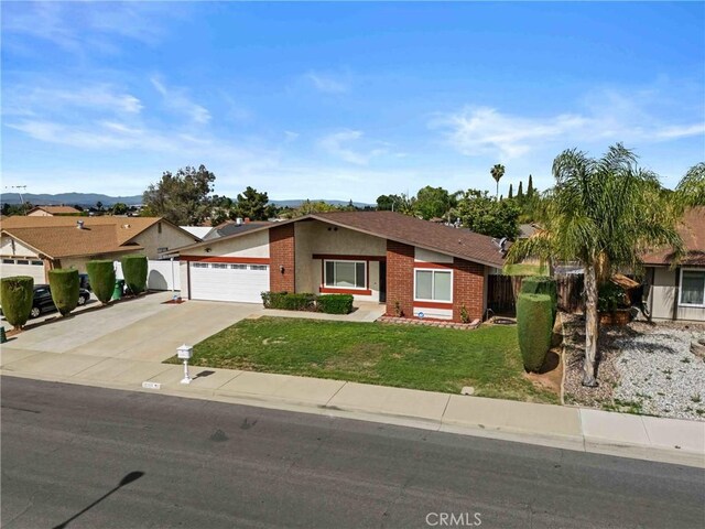 12705 Foreman Ave, Moreno Valley, CA 92553 - ranch-style house featuring brick siding, driveway, and a garage