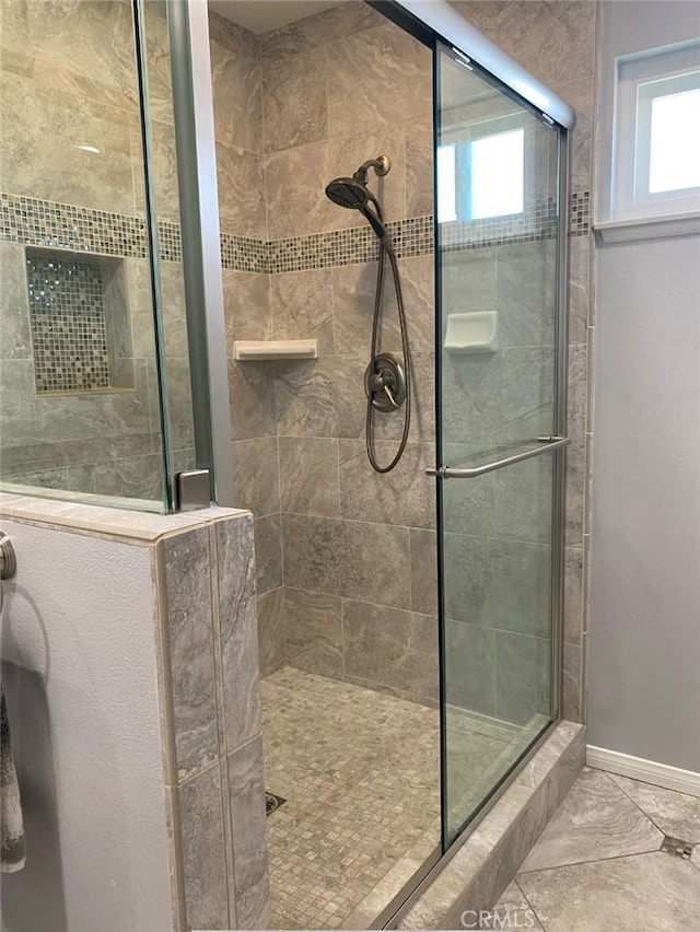 12705 Foreman Ave, Moreno Valley, CA 92553 - bathroom with a tile shower, healthy amount of natural light, and baseboards
