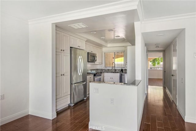 4004 Calle Sonora Oeste Unit 1F, Laguna Woods, CA 92637 - kitchen featuring stainless steel appliances, dark wood-type flooring, white cabinetry, ornamental molding, and a peninsula