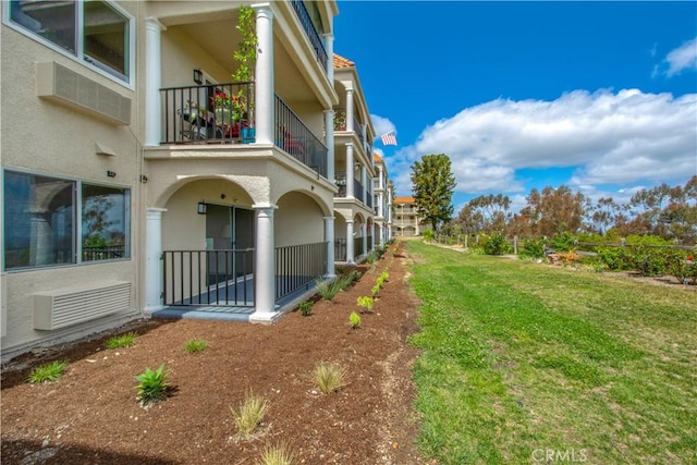 4004 Calle Sonora Oeste Unit 1F, Laguna Woods, CA 92637 - view of side of home featuring stucco siding, a balcony, and a lawn