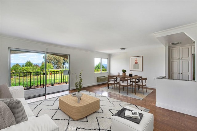 4004 Calle Sonora Oeste Unit 1F, Laguna Woods, CA 92637 - living room featuring crown molding, wood-type flooring, baseboards, and a wall unit AC