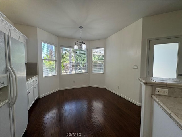 4809 Prairie Meadows Way, Bakersfield, CA 93312 - unfurnished dining area with dark wood-style flooring, a chandelier, and baseboards
