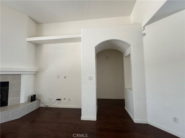 4809 Prairie Meadows Way, Bakersfield, CA 93312 - washroom featuring wood finished floors, arched walkways, a tile fireplace, and baseboards