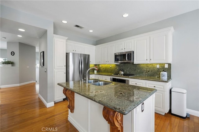 23423 Waterway Ln Unit 17, Valencia, CA 91355 - kitchen featuring stainless steel appliances, a sink, baseboards, light wood-style floors, and backsplash