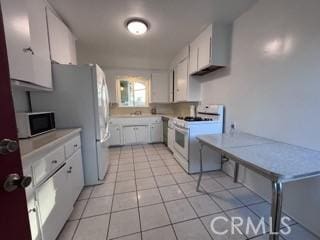 2020 W Swanee Ln, West Covina, CA 91790 - kitchen with white range with gas stovetop, light countertops, light tile patterned floors, and white cabinets