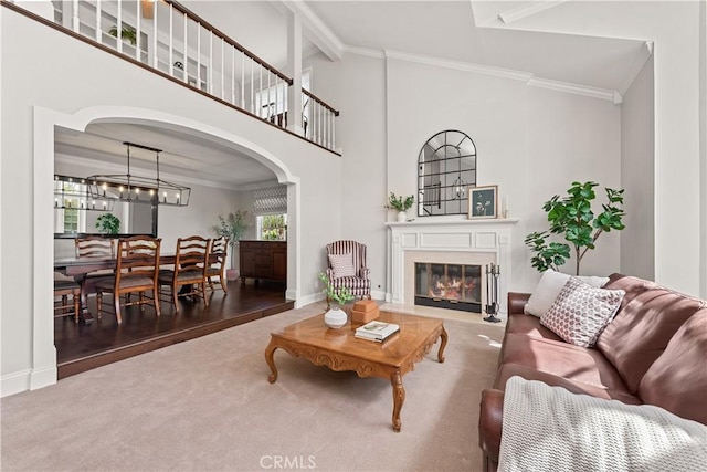 1280 Dumaine Ave, Oak Park, CA 91377 - carpeted living area featuring arched walkways, crown molding, a glass covered fireplace, baseboards, and vaulted ceiling