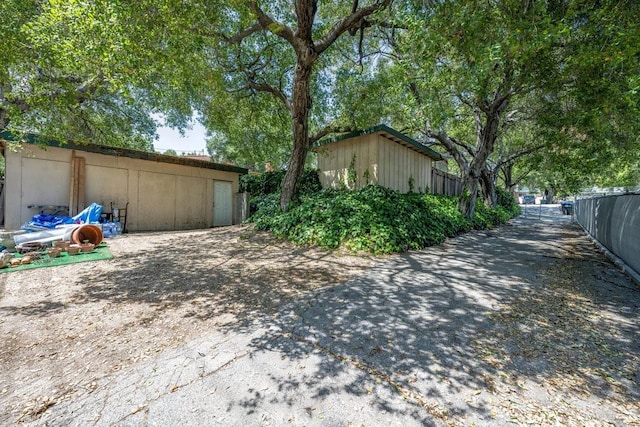 view of side of property featuring fence and an outbuilding