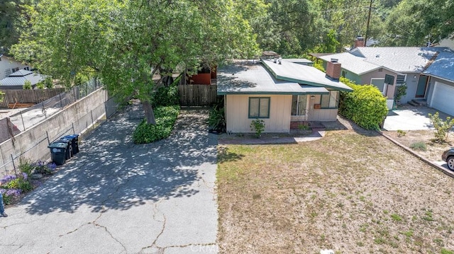 view of front of house featuring concrete driveway and fence