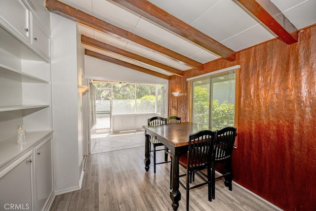 dining room with wooden walls and light wood finished floors