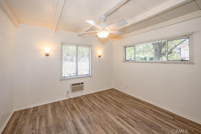 spare room with wood finished floors, beamed ceiling, a wall mounted air conditioner, baseboards, and a ceiling fan