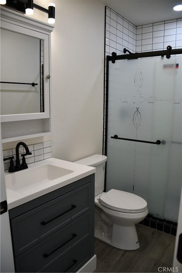 635 N Plumas St, Willows, CA 95988 - bathroom featuring wood finished floors, vanity, a shower stall, toilet, and backsplash