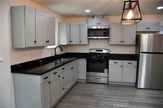 635 N Plumas St, Willows, CA 95988 - kitchen with stainless steel appliances, a sink, dark countertops, recessed lighting, and light wood-type flooring