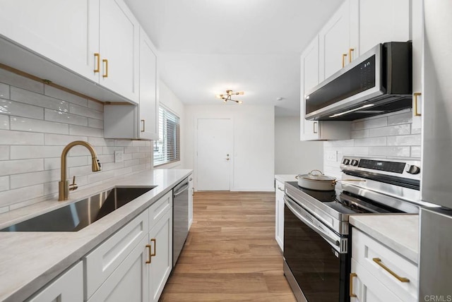 3825 Van Dyke Ave, San Diego, CA 92105 - kitchen with stainless steel appliances, a sink, decorative backsplash, and light wood-style flooring