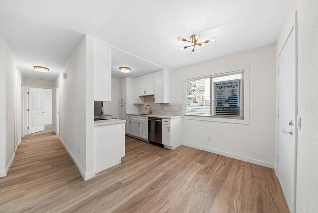 3825 Van Dyke Ave, San Diego, CA 92105 - kitchen with dishwasher, a sink, light wood-style flooring, light countertops, and white cabinets