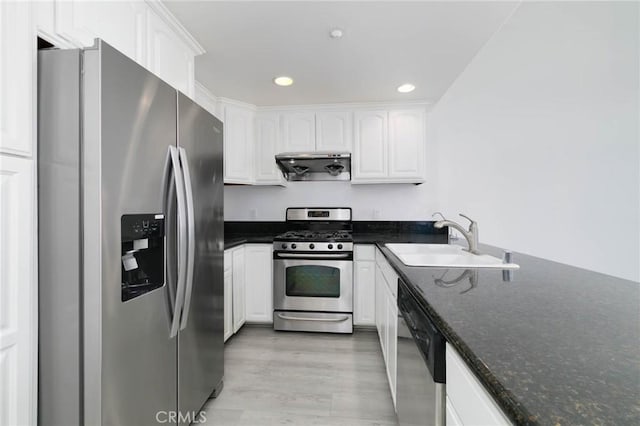 kitchen featuring appliances with stainless steel finishes, a sink, white cabinetry, light wood-style flooring, and recessed lighting