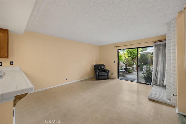 2622 N Tustin Ave Unit 147, Santa Ana, CA 92705 - unfurnished living room with a textured ceiling and baseboards