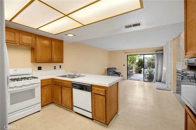 2622 N Tustin Ave Unit 147, Santa Ana, CA 92705 - kitchen with white appliances, a sink, open floor plan, a peninsula, and brown cabinets