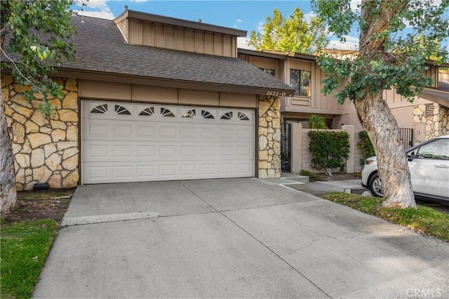 2622 N Tustin Ave Unit 147, Santa Ana, CA 92705 - view of front facade with stone siding, concrete driveway, roof with shingles, and a garage