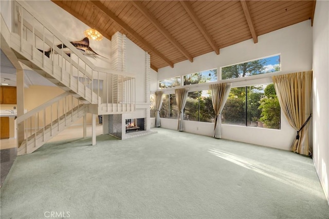 2622 N Tustin Ave Unit 147, Santa Ana, CA 92705 - unfurnished living room featuring high vaulted ceiling, carpet, wooden ceiling with exposed beams, stairs, and a fireplace