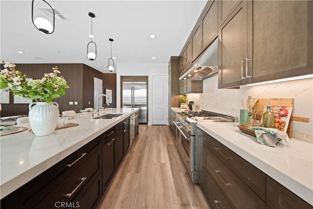 110 Mulberry, Lake Forest, CA 92630 - kitchen with high end appliances, a sink, under cabinet range hood, light wood-style flooring, and decorative light fixtures