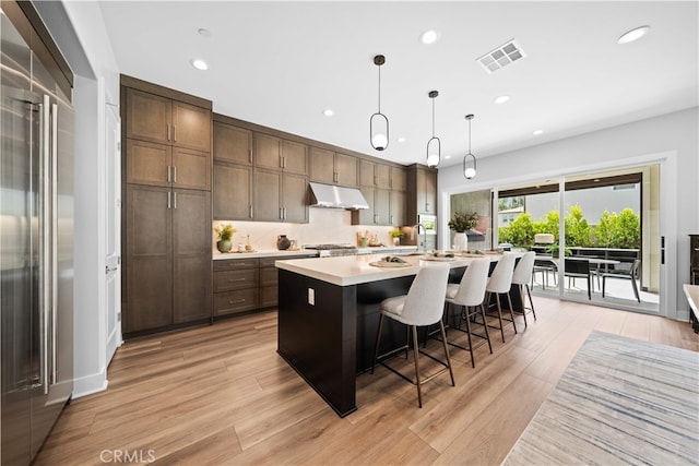 110 Mulberry, Lake Forest, CA 92630 - kitchen featuring under cabinet range hood, high end refrigerator, recessed lighting, light countertops, and a center island with sink