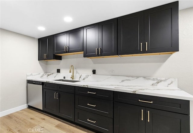 1000 Central Ave Unit 39, Riverside, CA 92507 - kitchen with stainless steel dishwasher, a sink, dark cabinets, light wood finished floors, and baseboards