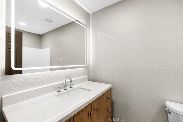 1000 Central Ave Unit 39, Riverside, CA 92507 - half bath featuring a textured wall, toilet, and vanity