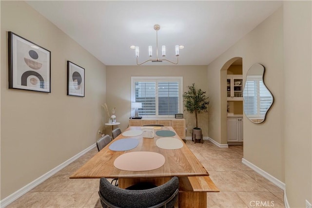 2551 Holly St, Fullerton, CA 92835 - dining area featuring a chandelier, arched walkways, baseboards, and light tile patterned floors