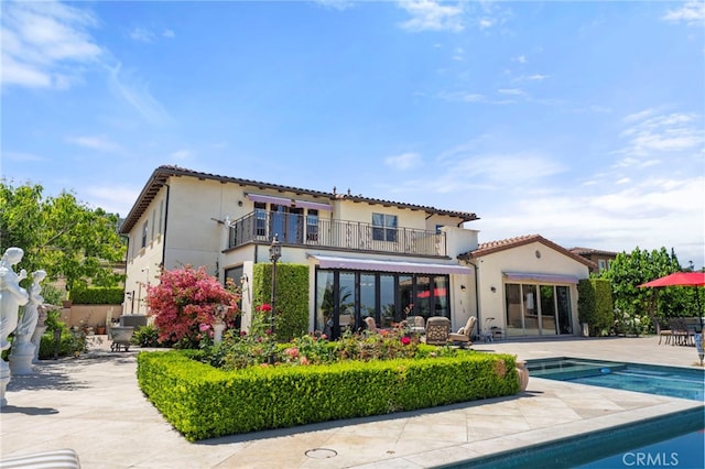 2825 Majestic St, West Covina, CA 91791 - rear view of house with a balcony, an outdoor pool, stucco siding, a patio area, and a tiled roof