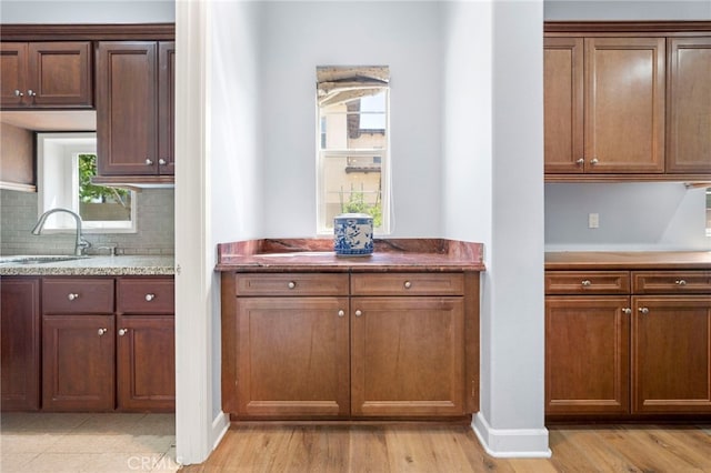 2825 Majestic St, West Covina, CA 91791 - kitchen featuring a sink, decorative backsplash, light wood finished floors, and baseboards