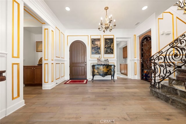 2825 Majestic St, West Covina, CA 91791 - foyer entrance with a decorative wall, arched walkways, stairway, a chandelier, and light wood-style flooring