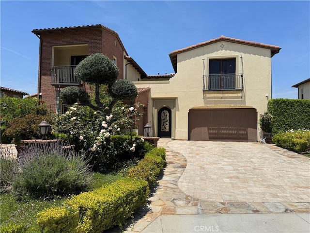 2825 Majestic St, West Covina, CA 91791 - mediterranean / spanish home with a balcony, an attached garage, a tiled roof, stucco siding, and decorative driveway