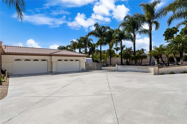 4009 Cerveza Cir, Corona, CA 92881 - view of front facade featuring stucco siding, concrete driveway, a garage, a tile roof, and fence